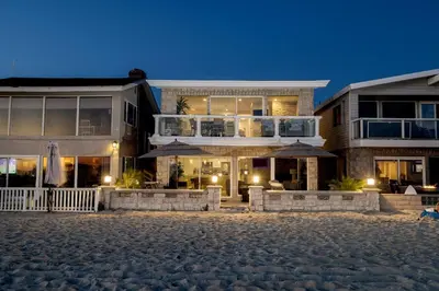 a large house with a patio and a balcony at 8BR Beach Duplex with Ocean Views, Patio & Pool Table in Newport Beach