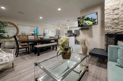 a living room with a tv on a wall at 8BR Beach Duplex with Ocean Views, Patio & Pool Table in Newport Beach