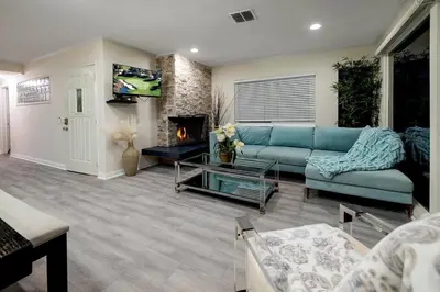 a living room with a blue couch and a fireplace at Spacious 5BR Beach Home with Ocean Views in Newport Beach