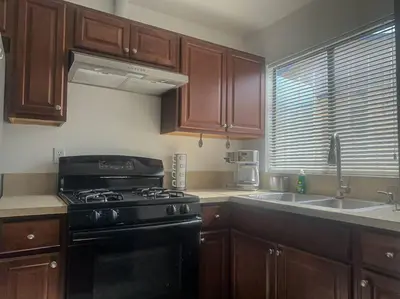 a kitchen with a black stove and a sink at Fabulous Guesthouse in Mount Helix La Mesa in Grossmont