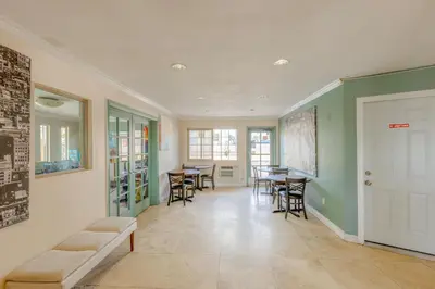 a living room with chairs and tables and a door at Hotel Avenida - Oceanside Camp Pendleton in Oceanside