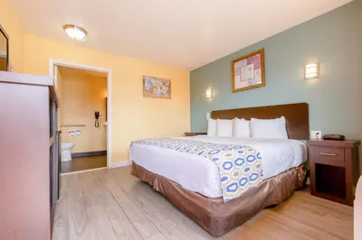 a hotel room with a large bed and a bathroom at Hotel Avenida - Oceanside Camp Pendleton in Oceanside