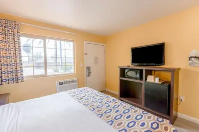 a bedroom with a bed and a flat screen tv at Hotel Avenida - Oceanside Camp Pendleton in Oceanside