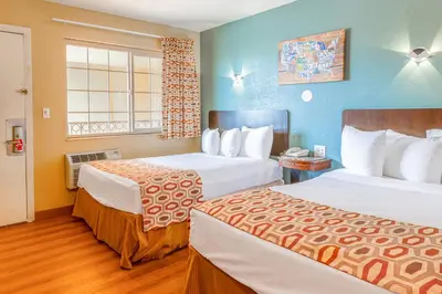 a hotel room with two beds and a window at Hotel Avenida - Oceanside Camp Pendleton in Oceanside