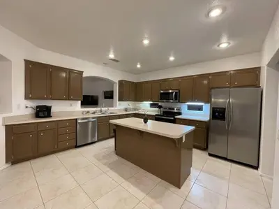 a large kitchen with wooden cabinets and stainless steel appliances at Cozy Pet-Friendly Residence in Menifee