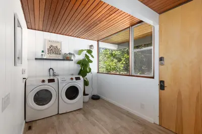 a laundry room with a washing machine and a window at Mid-Century Masterpiece Tree house, Pool & Spa in Escondido