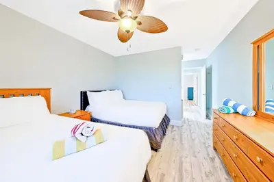 a bedroom with two beds and a ceiling fan at Newport Beach Condo with Patio Perfect Location on the Boardwalk in Newport Beach