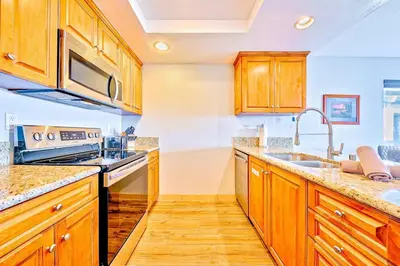 a kitchen with wooden cabinets and a sink at Condo in Newport Beach with Private Balcony and Ideal Location by the Pier in Newport Beach