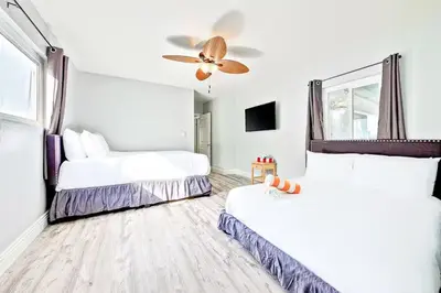 a bedroom with two beds and a ceiling fan at Balboa Peninsula Hidden Gem with Private Balcony & Stunning Views in Newport Beach