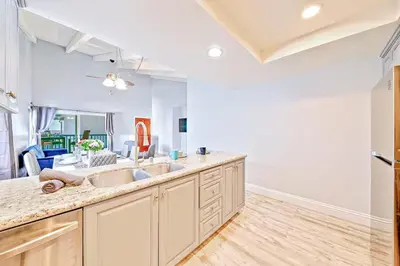 a kitchen with two sinks and a living room at Balboa Peninsula Hidden Gem with Private Balcony & Stunning Views in Newport Beach