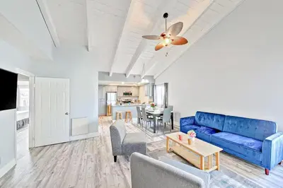 a living room with a blue couch and a table at Balboa Peninsula Hidden Gem with Private Balcony & Stunning Views in Newport Beach