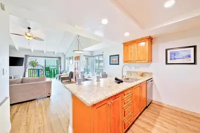 a kitchen with a counter top and a living room at Oceanfront Condo in Newport Beach with Private Balcony and Perfect Location by the Pier in Newport Beach