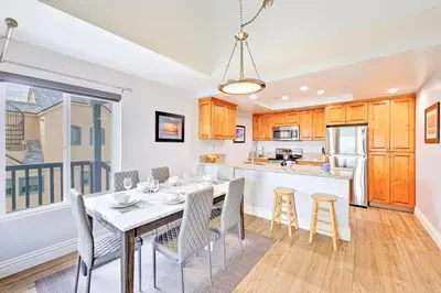 a kitchen and dining room with a table and chairs at Oceanfront Condo in Newport Beach with Private Balcony and Perfect Location by the Pier in Newport Beach