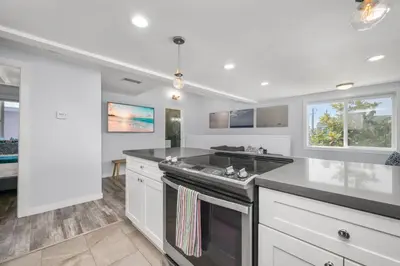 a kitchen with white cabinets and a stove top oven at Perfect Surf Casa in Newport Near Beach and Pier in Newport Beach