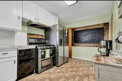 a kitchen with white cabinets and a black appliances at Rustic Coastal Retreat in Sunset Cliffs three beds & two baths in San Diego
