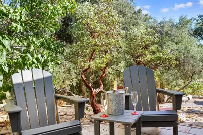 two chairs and a table with a wine glass at Julian Cafe Cottages With Breakfast At The Julian Cafe in Julian