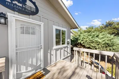 a house with a white garage door and a deck at Julian Cafe Cottages With Breakfast At The Julian Cafe in Julian