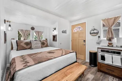 a bedroom with a large bed and a kitchen at Julian Cafe Cottages With Breakfast At The Julian Cafe in Julian
