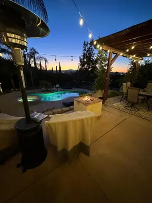 a patio with a table and a pool at night at Secluded Paradise Oasis with Gorgeous Pool in El Cajon