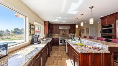 a large kitchen with wooden cabinets and a large window at Chardonnay Charm by AvantStay Luxe Group Retreat w Pool Mins to Wineries in Country Road Estates
