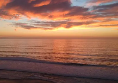 a sunset on the beach with the ocean at Ocean, Bay, Downtown, and City view Condo, Few steps from the ocean in San Diego