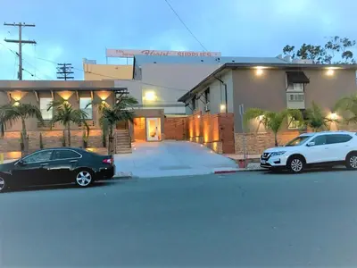 two cars parked in front of a house at Berkshire Motor Hotel in San Diego