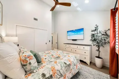 a bedroom with a bed and a flat screen tv at Walk To The Waves Newport Beach House in Newport Beach