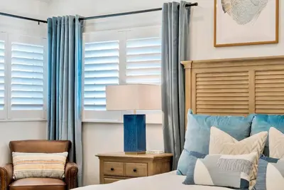 a bedroom with a bed and a chair at Walk To The Waves Newport Beach House in Newport Beach