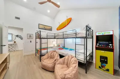 a room with two bunk beds and a tv at Walk To The Waves Newport Beach House in Newport Beach