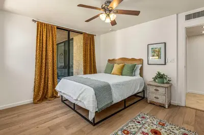 a bedroom with a bed and a ceiling fan at La Jolla Gem condo in San Diego