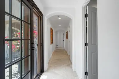 a hallway with white walls and an arched doorway at Grand Mediterranean Villa in La Jolla Hillside in San Diego