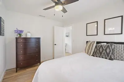 a bedroom with a bed and a ceiling fan at Coastal Palm Haven - With Hot Tub in Carlsbad