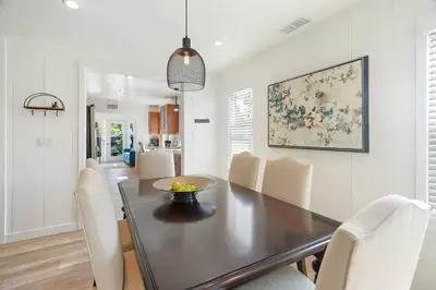 a dining room with a black table and chairs at Coastal Palm Haven - With Hot Tub in Carlsbad