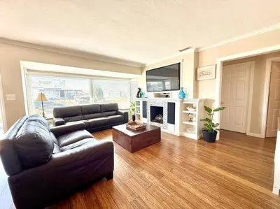 a living room with a leather couch and a fireplace at The Cozy Ranch Retreat in San Diego