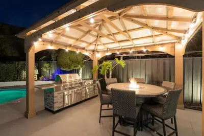a patio with a table and chairs and a swimming pool at Designer Family Home with Resort-Style Oasis in San Diego