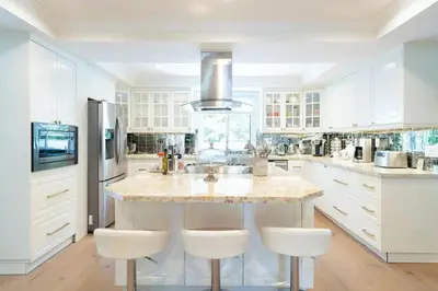 a kitchen with white cabinets and a island with bar stools at Luxurious Family 5 Bedroom Getaway in San Diego