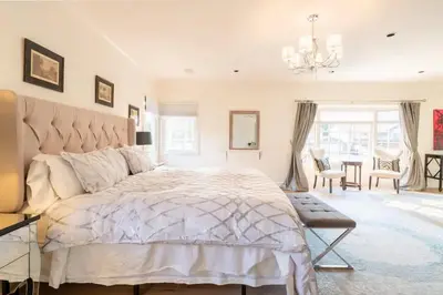 a bedroom with a large bed and a dining room at Luxurious Family 5 Bedroom Getaway in San Diego
