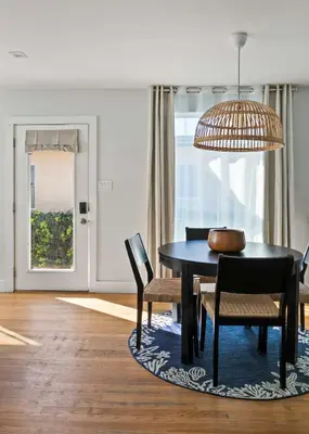 a dining room with a black table and chairs at Beach Abode Walk to the Ocean in San Diego