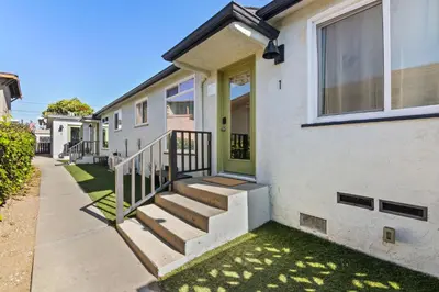 a house with stairs and a green door at Beach Abode Walk to the Ocean in San Diego