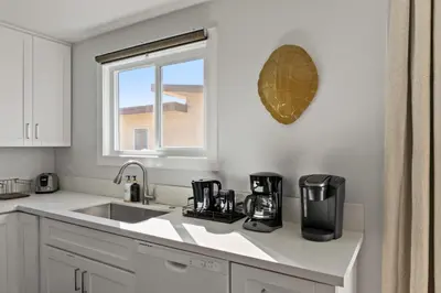 a white kitchen with a sink and a window at 6 Bedroom Family Getaway Walk to Law Street Beach in San Diego