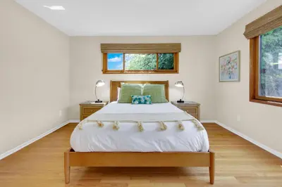a white bedroom with a bed and two lamps at Pacific Views Retreat - Rooftop Deck, Game Room, Fire Pit & Cozy Backyard! in San Diego