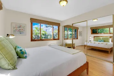 a bedroom with a large white bed and a bathroom at Pacific Views Retreat - Rooftop Deck, Game Room, Fire Pit & Cozy Backyard! in San Diego