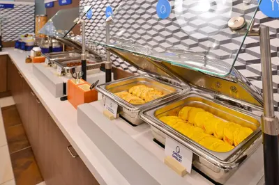 a buffet line with trays of food on display at Holiday Inn Express & Suites San Diego - Mission Valley by IHG in San Diego