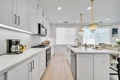 a kitchen with white cabinets and a counter top at Dreamy Bloom Enclave Irivne LA RMV in American Display Heliport