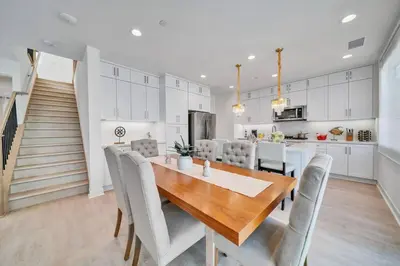 a kitchen and dining room with a wooden table and chairs at Dreamy Bloom Enclave Irivne LA RMV in American Display Heliport