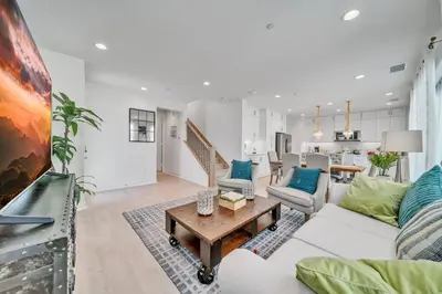 a living room with a white couch and a table at Dreamy Bloom Enclave Irivne LA RMV in American Display Heliport