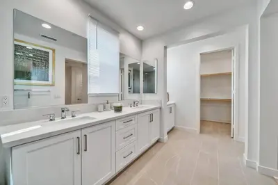 a white bathroom with two sinks and a large mirror at Dreamy Bloom Enclave Irivne LA RMV in American Display Heliport
