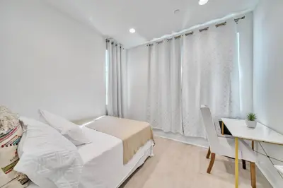 a bedroom with a bed and a desk and a window at Dreamy Bloom Enclave Irivne LA RMV in American Display Heliport