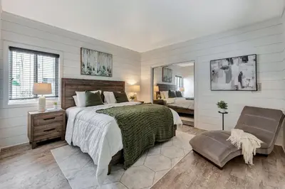 a bedroom with a bed and a chair and a mirror at Steps to Lido Village and the Marina Heart of Lido Island WITH PARKING in Newport Beach