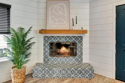 a fireplace in a living room with a blue and white tile at Steps to Lido Village and the Marina Heart of Lido Island WITH PARKING in Newport Beach